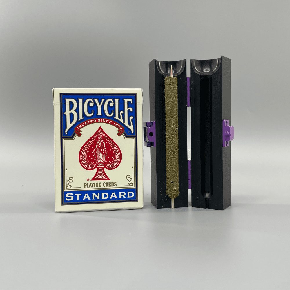 CannaMold kit displayed next to a deck of playing cards demonstrating that the weed cigar maker is slighlty taller than a pack of cards and the Cannagar can pack 2-4g of cannabis.