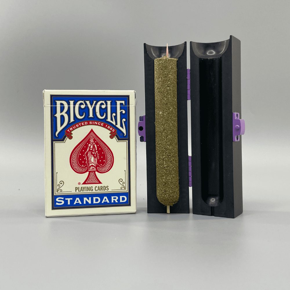 Large cannagar packed inside its cannamold custom blunt roller and shown next to a deck of playing cards to show size comparison. The Large cannagar is 1-2” longer than the pack of cards, and about ⅓ the width.