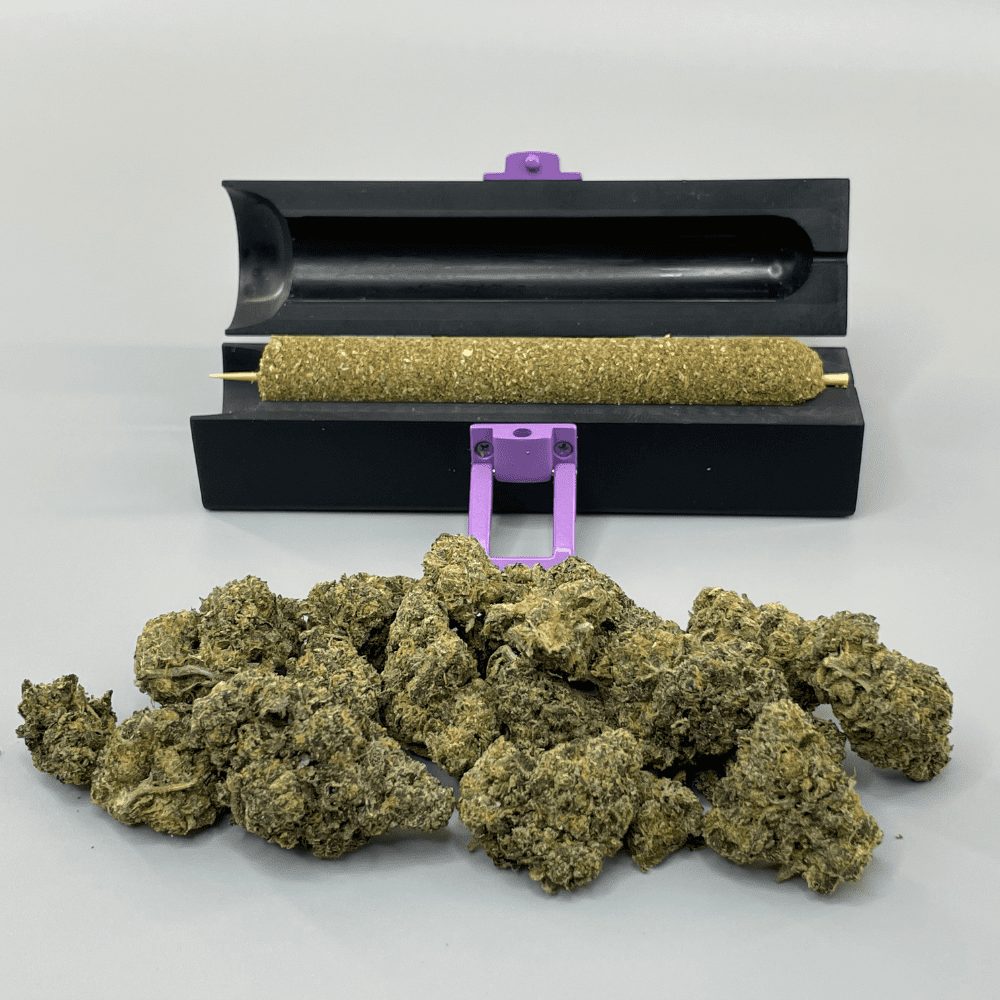Large Cannagar mold fits 10-14 grams of weed, and to illustrate this, a large pile of 10 grams of cannabis buds are in the foreground and a group-sized blunt cannagar is displayed on the blunt machine.