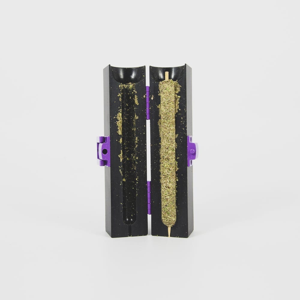 A personal cannabis cigar kit, the Purple Rose Supply CannaMold, is shown packed with 2-4g of marijuana, which was cured with the airflow skewer and is ready for a hemp leaf blunt wrap.