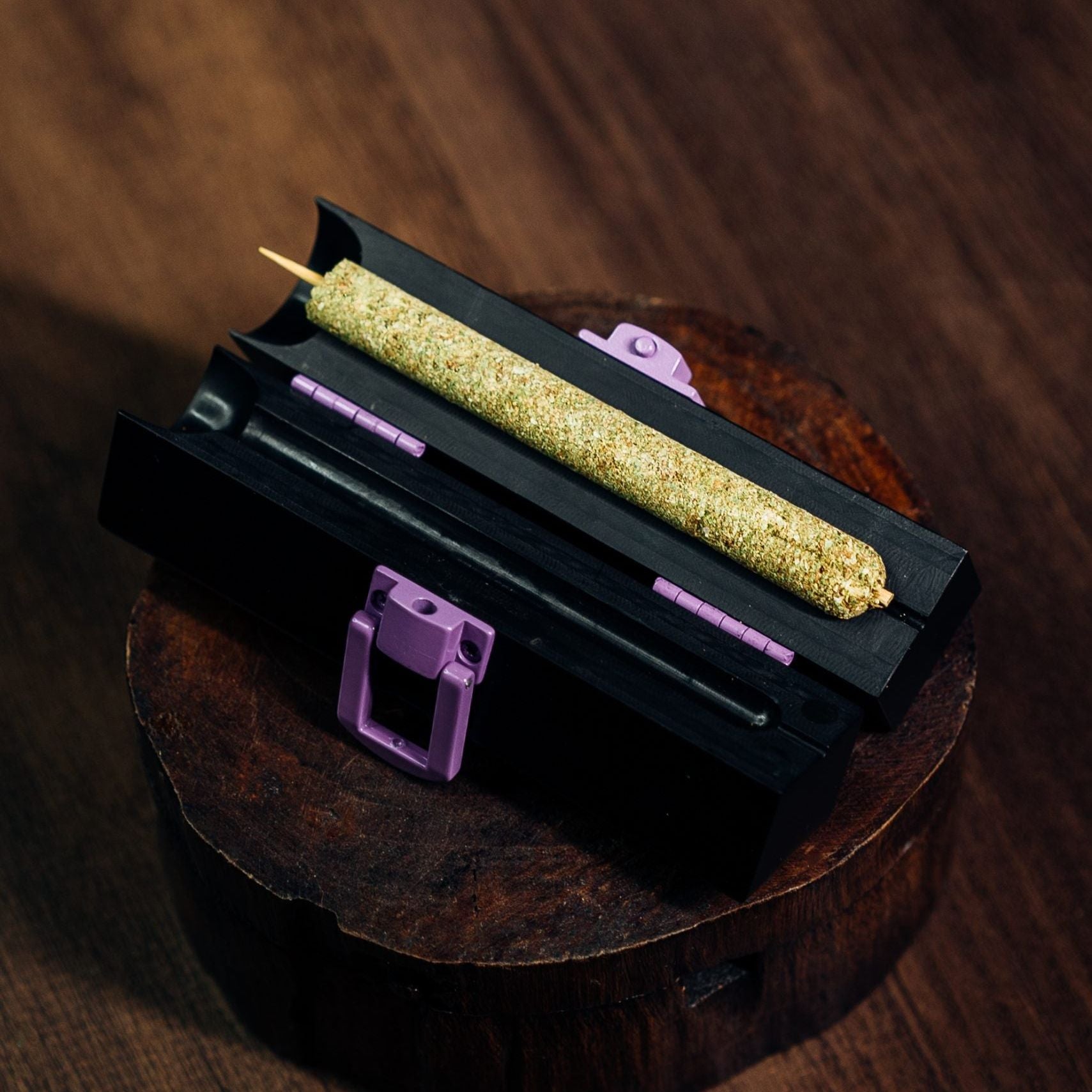 Part joint, part blunt. This personal-sized cannamold kit is displayed upon its packaging with a cured, 2-4g cannagar. The background is a rich, wood-grain.